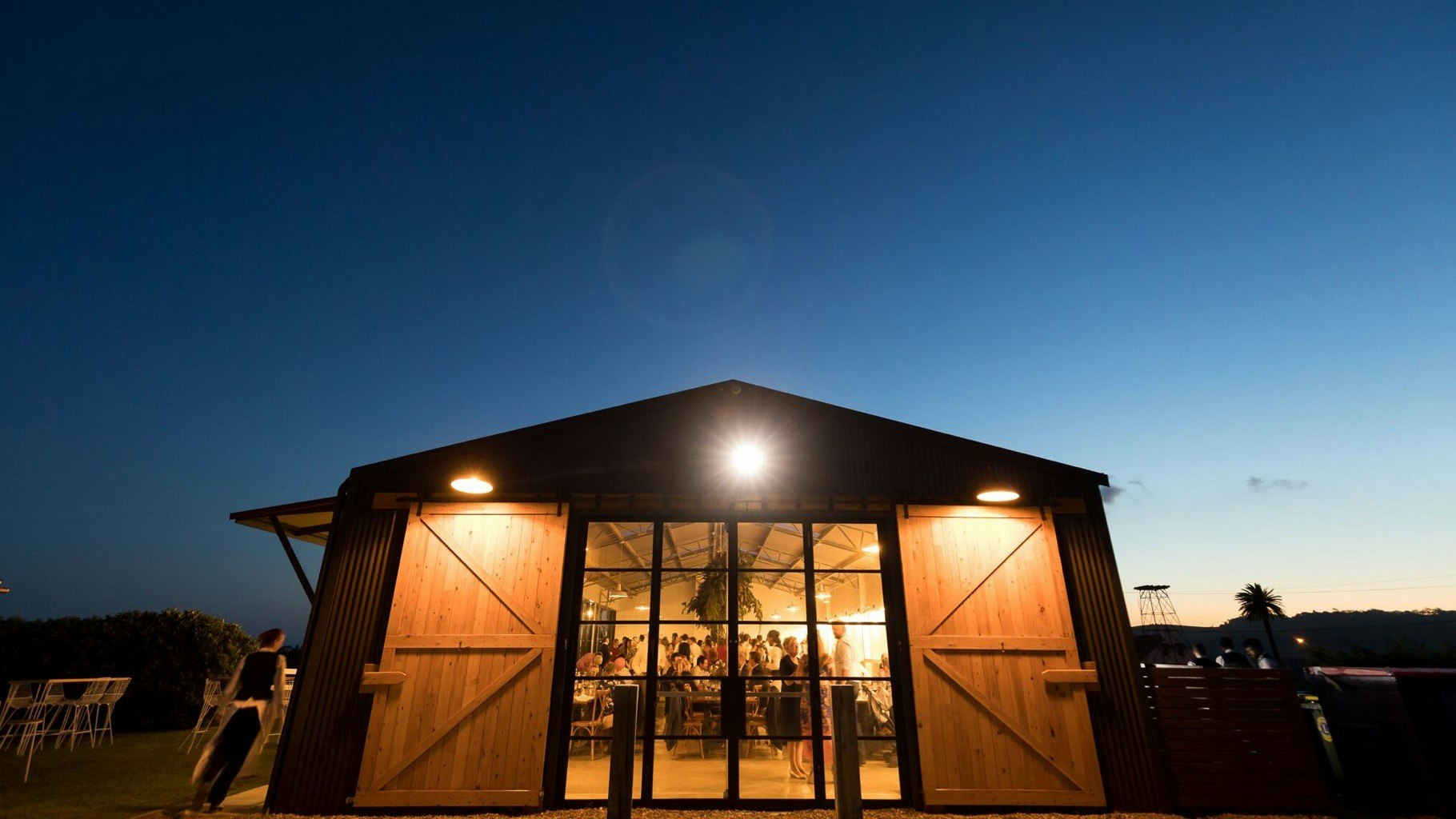 Barn under night sky with wedding guests inside.